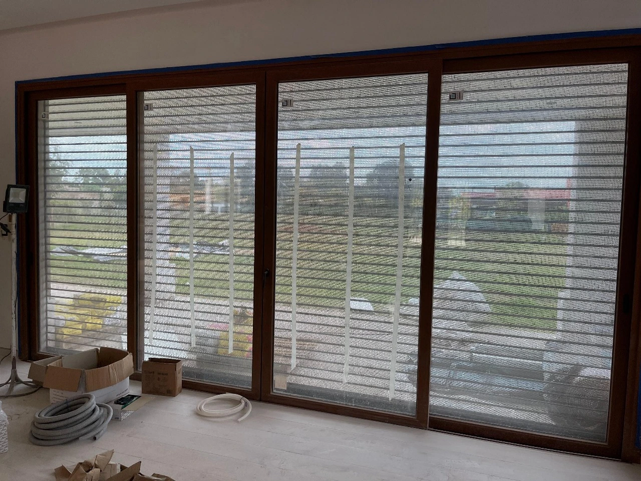 Cortina metálica siendo instalada en un ambiente calido con vista al exterior